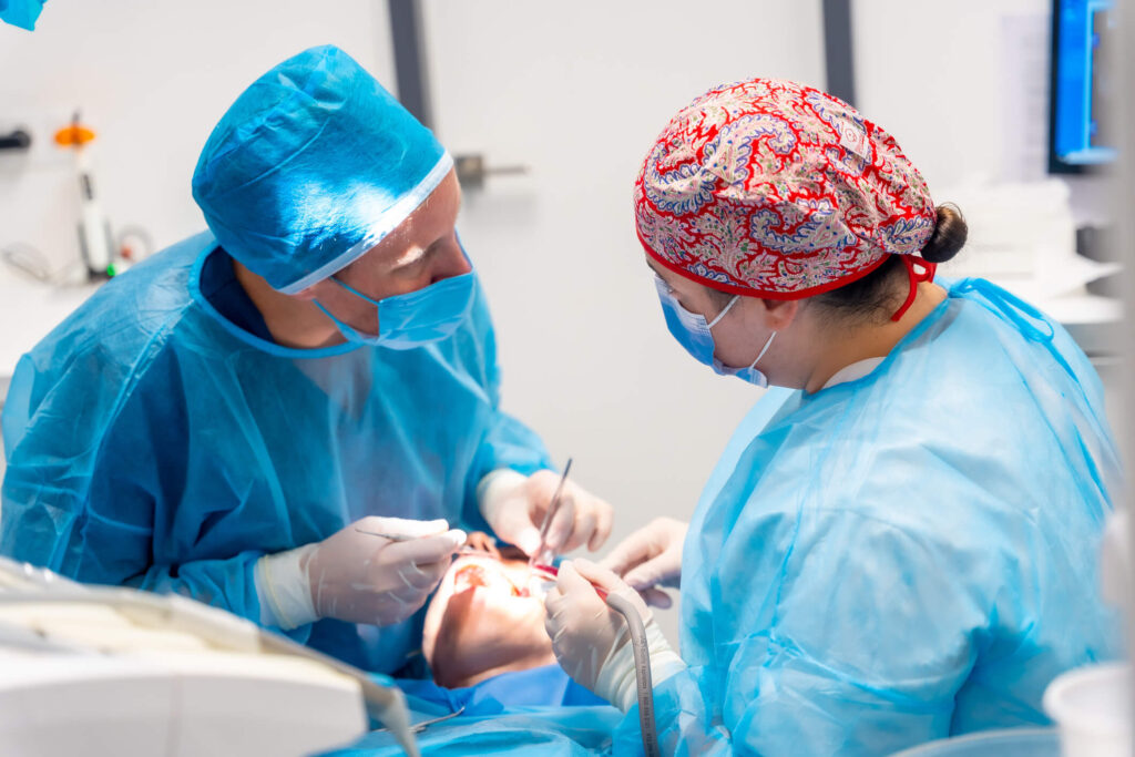 Oral surgeon and dentist in conversation during dental surgery